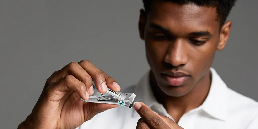 Man using precision nail clippers, close-up on hands and grooming tool