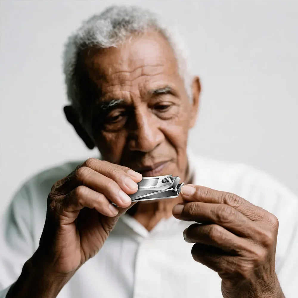 Senior man using stainless steel nail clippers for precise nail grooming